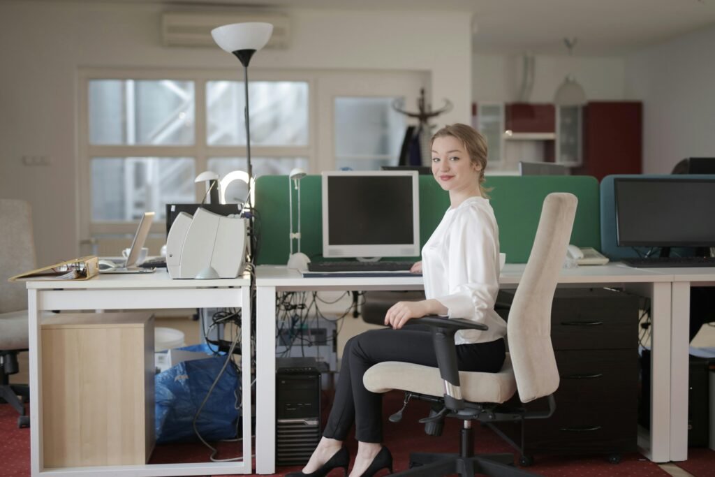 Confident businesswoman sitting at a desk in a modern office setting.